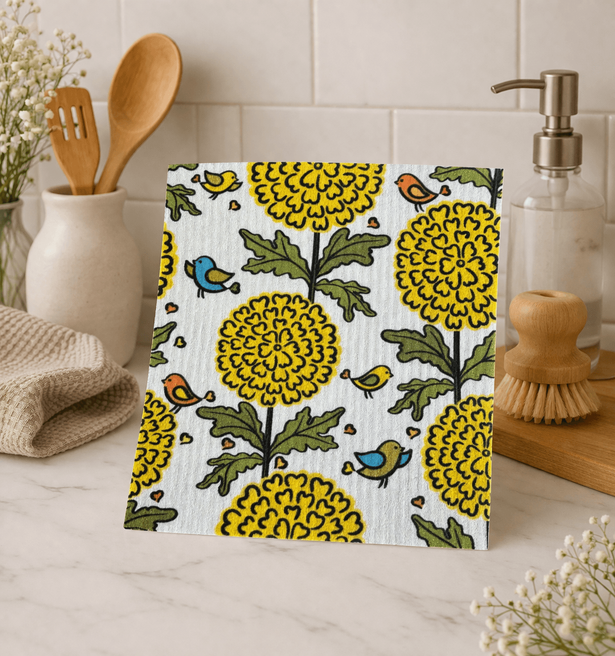 Swedish dishcloth with yellow floral and bird pattern styled in a bright kitchen setting